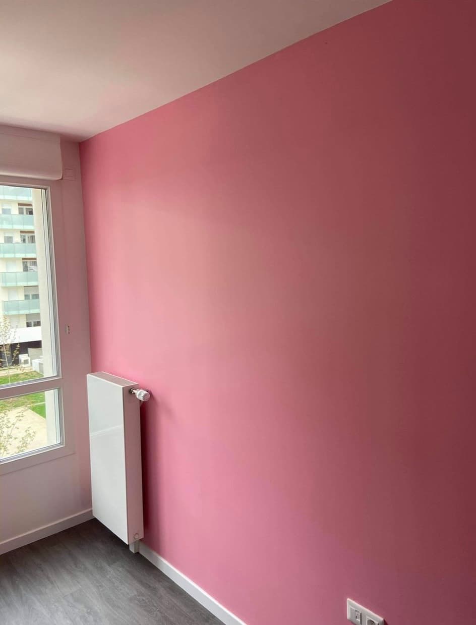 Chambre rénovée par RBP : mur rose mat, plafond blanc, finition propre