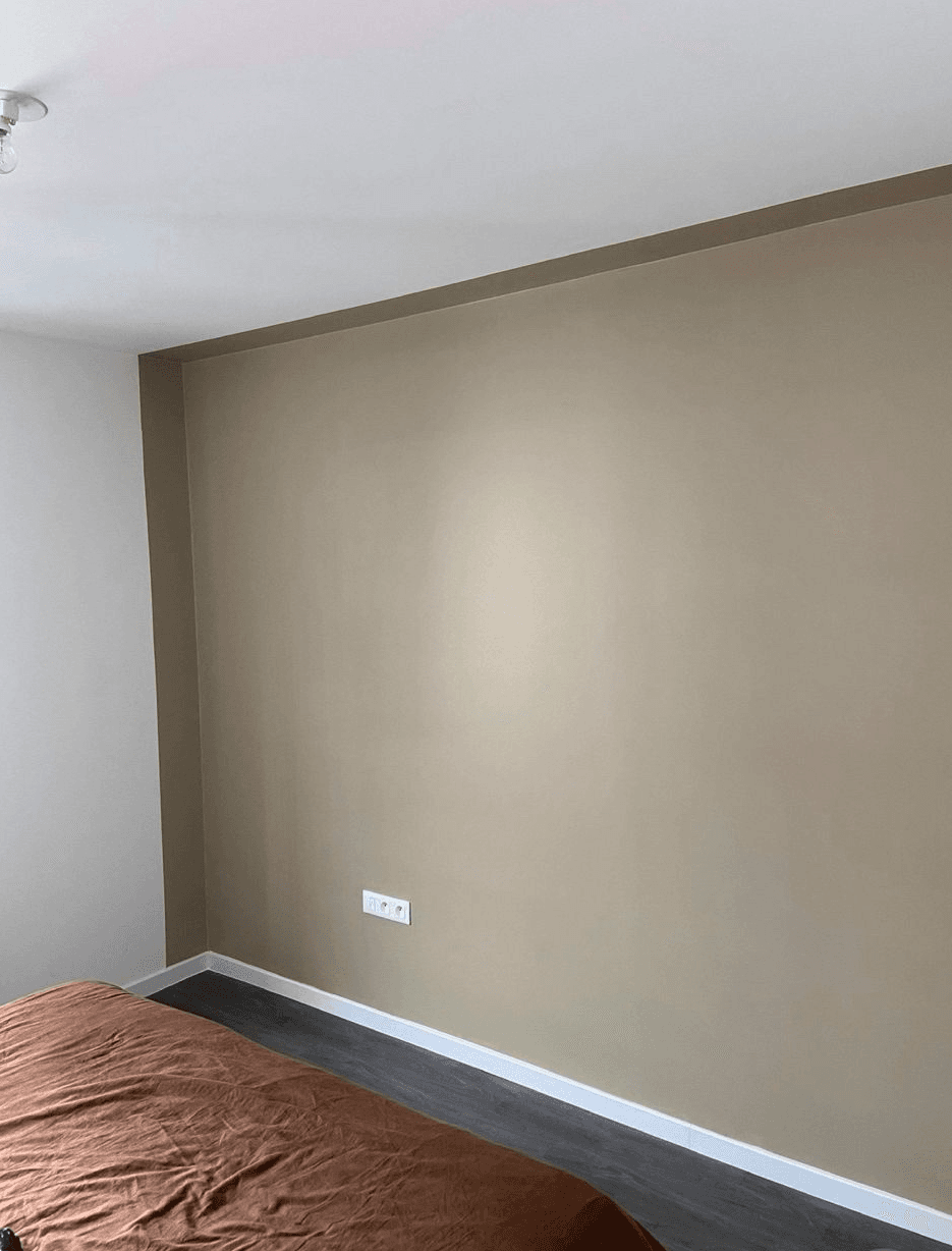 Chambre peinte en taupe, sol stratifié sombre, plinthes blanches