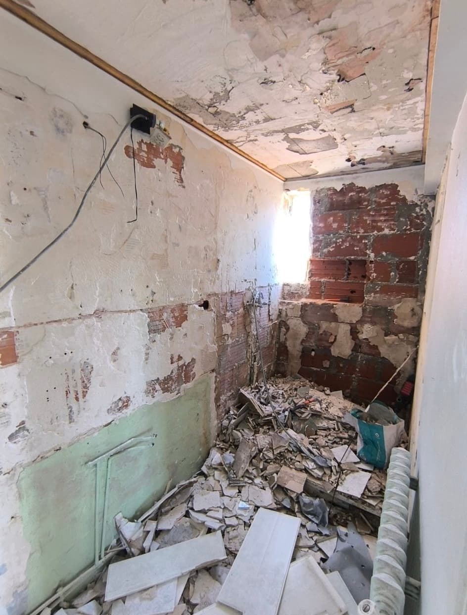 Salle de bain en démolition, murs nus, gravats au sol